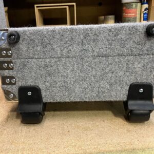 A gray felt Wheeled Case on a workbench.