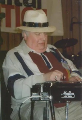 A man in a hat playing a keyboard.