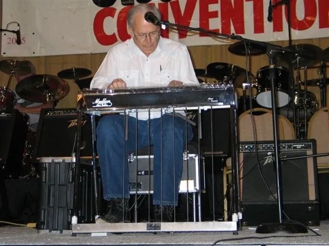 A man playing a keyboard in front of a microphone.