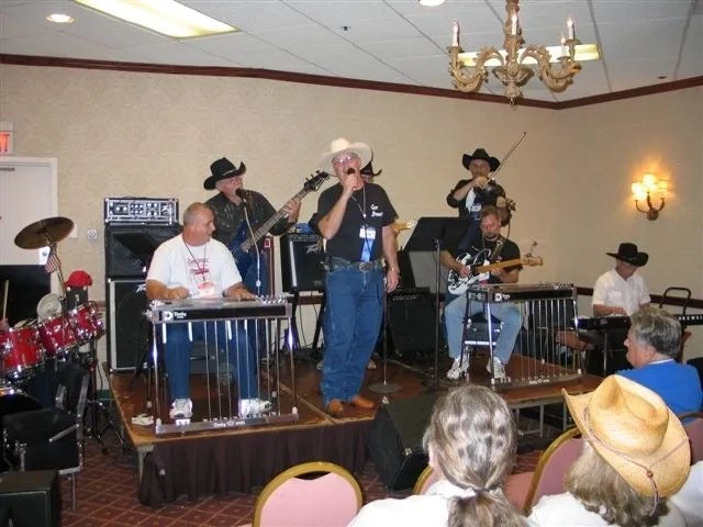 A group in cowboy hats playing music in a room.