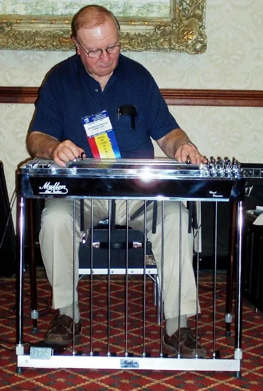 A man sitting in a chair playing a musical instrument.