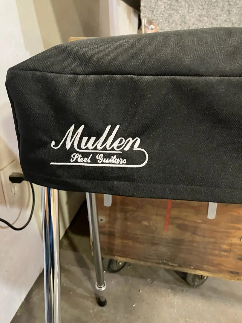 A black Mullen Guitar Dust Cover for a stool